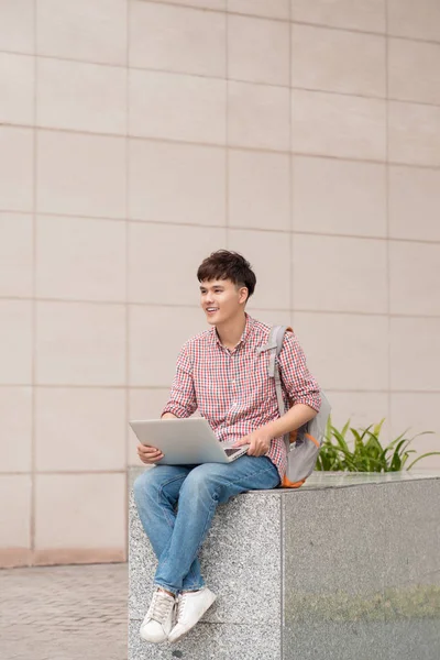 erkek öğrenci dizüstü kullanarak