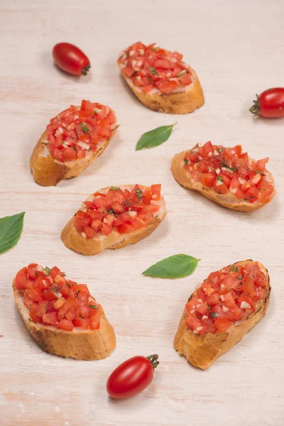 Heerlijke Italiaanse bruschetta met brood gegarneerd met tomaat en kruid — Stockfoto