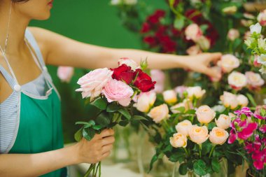 Çiçekçide güzel buket yapan kadın çiçekçi.