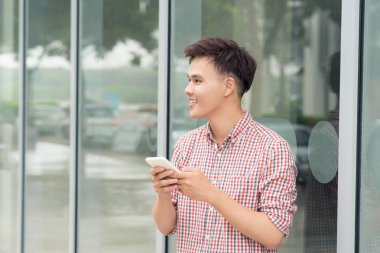 Gençler şehirde bina dışında cep telefonu ile