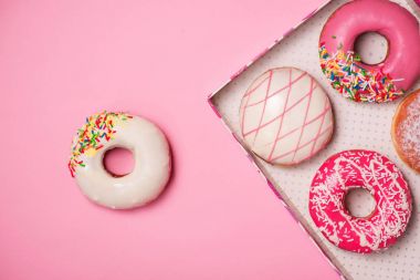 Pastel pembe arka planda kremalı çörekler. Tatlı çörekler..