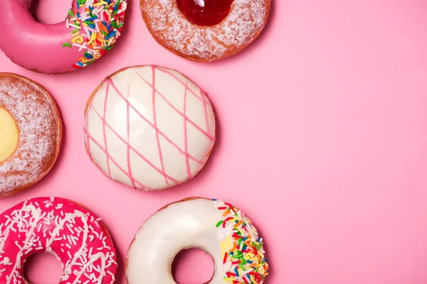 Donuts con glaseado sobre fondo rosa pastel. Rosquillas dulces. — Foto de Stock