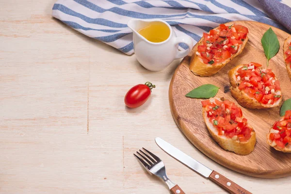 Sabrosa bruschetta italiana con pan cubierto con tomate y hierba —  Fotos de Stock