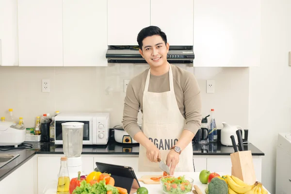 Joven asiático guapo hombre preparando comida en cocina en casa — Foto de Stock