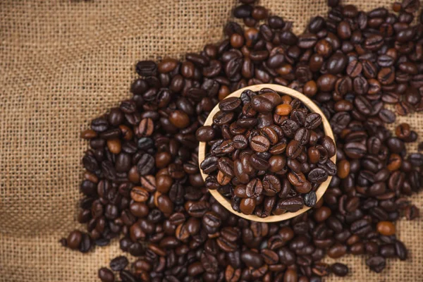 Rustik zemin üzerine kavrulmuş kahve çekirdekleri ile ahşap kase.