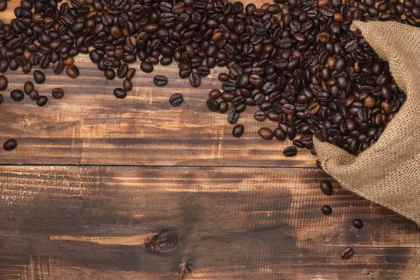 Granos de café marrón fresco sobre fondo de madera . — Foto de Stock