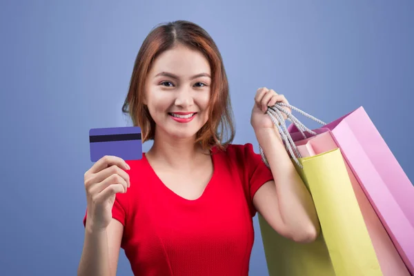 Santa donna asiatica in possesso di borse della spesa e carta di credito contro — Foto Stock