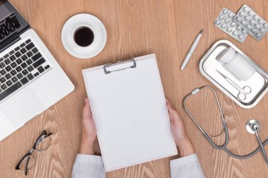 Top Yetişkin doktor pano ile çalışma masasının üzerinde görünümünü ve 