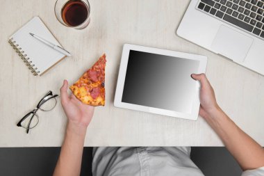 Bir dijital tablet ve malzemelerle lezzetli pizza tutan adam