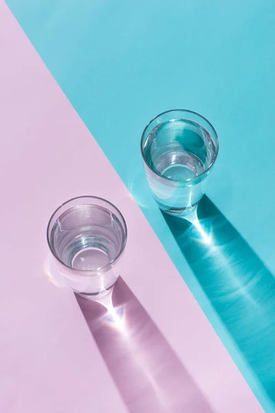 Πρωινή ώρα. Ποτήρι νερό σε πολύχρωμο φόντο — Φωτογραφία Αρχείου