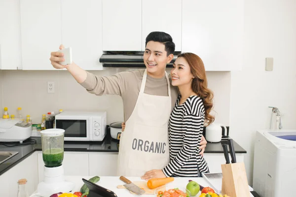 Щаслива азіатська пара посміхається і готує на кухні робить себе — стокове фото