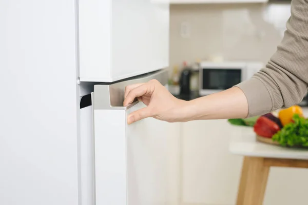 Male hand is opening white refrigerator door — Stock Photo, Image