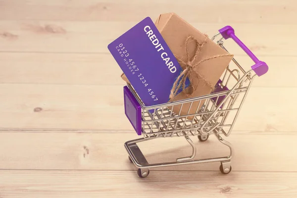Kreditní karta a nákupní vozík s dárkové krabice zabalené s papíru k — Stock fotografie
