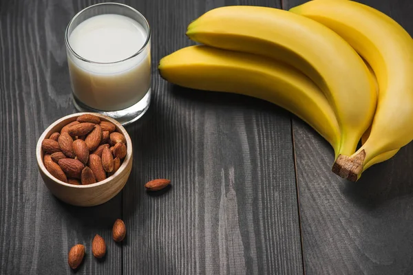 Badem ve ahşap arka plan üzerinde süt ile muz banch.