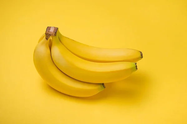 Un banc de bananes sur fond jaune . — Photo
