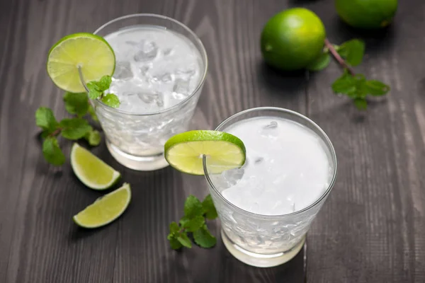 Fresh cocktail with lime, ice and mint on a rustic background. C — Stock Photo, Image
