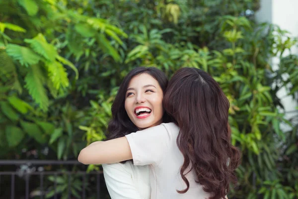 Arkadaşlar gülümsüyor ve sarılıyorlar.