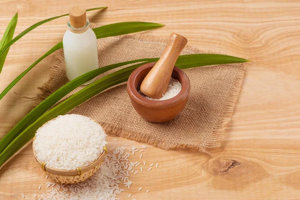 Rice flour in a wooden bowl, milk and rice on the old wooden bac — Stock Photo, Image