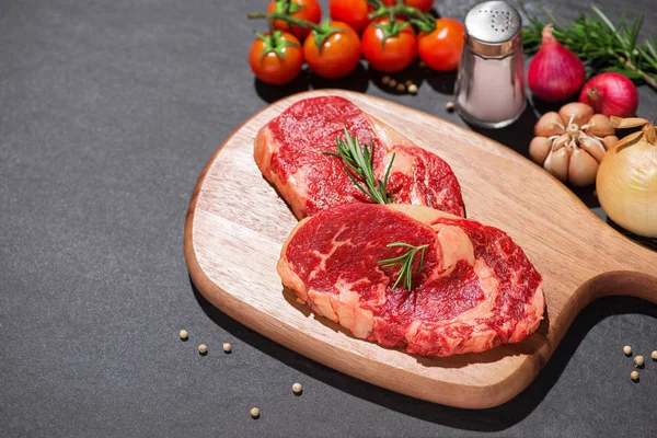 Carne cruda en una tabla de cortar con especias e ingredientes para el coo —  Fotos de Stock