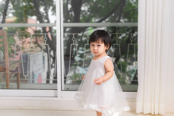 Menina brincando perto da janela — Fotografia de Stock