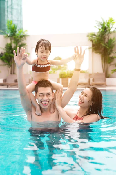 Familia feliz en la piscina. Vacaciones de verano y conc vacaciones —  Fotos de Stock