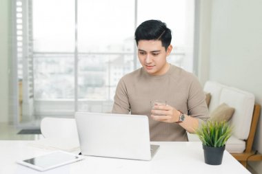 dizüstü bilgisayar kullanan gülümseyen genç adam