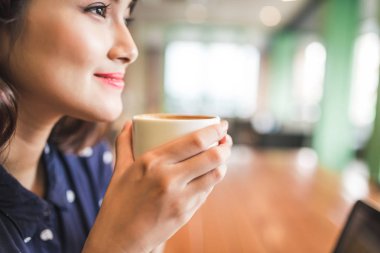 Genç bayan kahve içiyor.