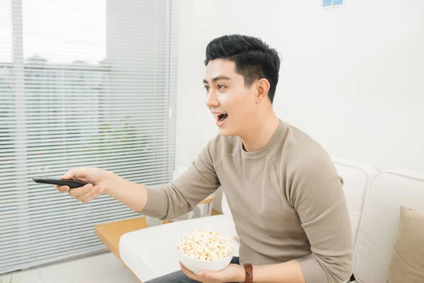 Hombre comiendo palomitas de maíz y viendo películas — Foto de Stock