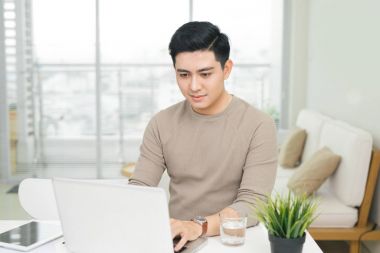 Evde dizüstü bilgisayar kullanan bir adam