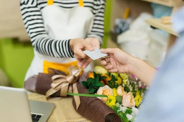 Florista dando cartão ao cliente — Fotografia de Stock