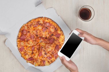 Adam holding smartphone ve pizza 
