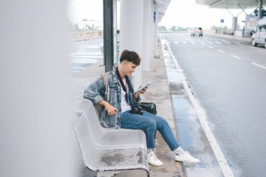 otobüs durağı üzerinde oturan adam 