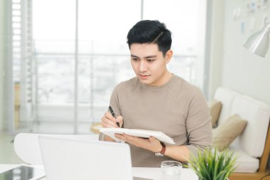 Evde dizüstü bilgisayar kullanan bir adam