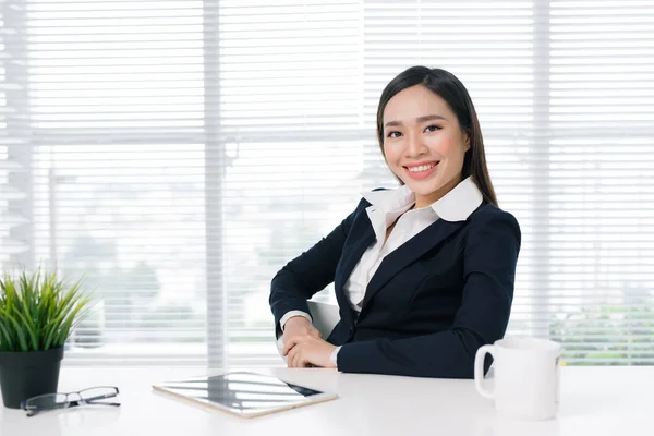 Businesswoman sitting at desk — Stock Photo, Image