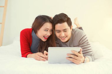 tablet ile yatakta yatarken Çift