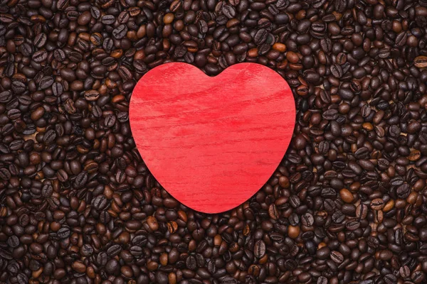 Forma de corazón rojo en granos de café — Foto de Stock