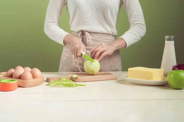 Женщина режет зеленое яблоко — стоковое фото