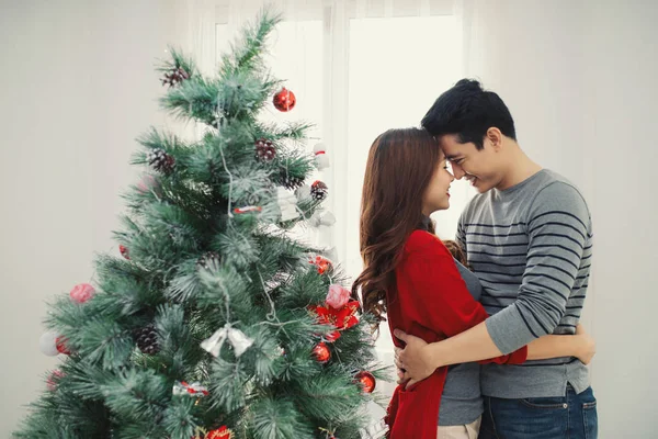 couple hugging near christmas tree