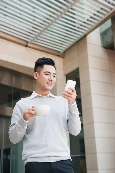 Guapo Joven Bebiendo Café Usando Teléfono Móvil Ciudad —  Fotos de Stock