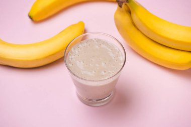 Sarı bir arka plan üzerinde Muz Smoothie. Seçici odak