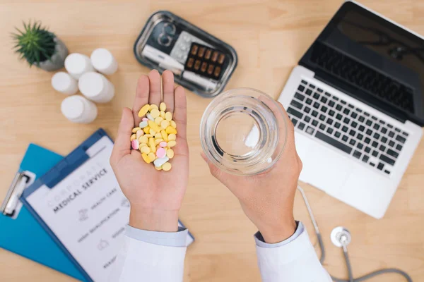 Farklı renkli kapsül tutan erkek doktor el. Tıbbi tedavi, antibiyotik direnç sorunu ve akılcı ilaç kullanımı kavramı. Seçici odak.