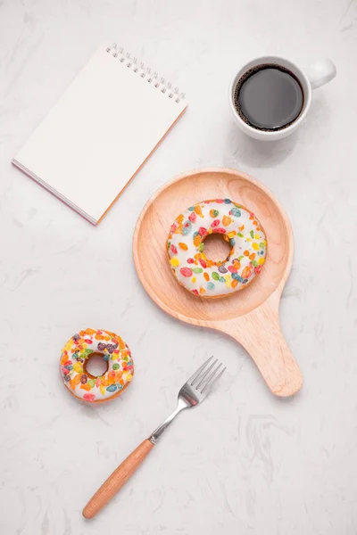 Working desk with dessert and coffee. Cake donuts with a cup of espresso on marble table top.