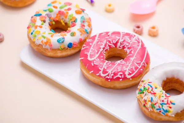 休日のための準備 ピンクの背景にカラフルなアメリカン ドーナツ — ストック写真