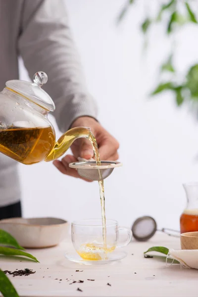 健康茶を注ぐ 木製テーブルの上のガラスのティーポットで熱いお茶 — ストック写真