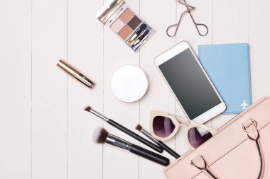 Kozmetik kadın ve moda öğeleri ile fotoğraf makinesi ve pasaport masada. Üstten Görünüm