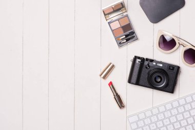 Kozmetik kadın ve moda öğeleri ile fotoğraf makinesi ve pasaport masada. Üstten Görünüm
