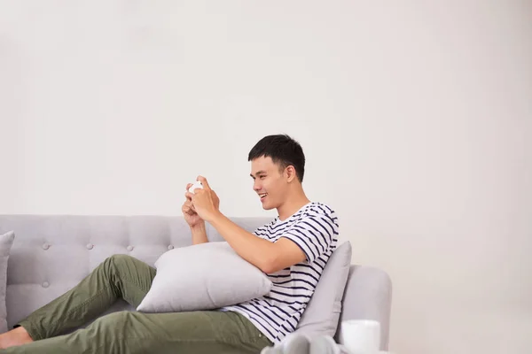 Junge Asiatische Mann Sitzt Auf Dem Sofa Und Spielt Spiele — Stockfoto