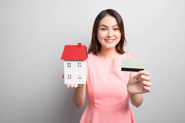 Encantadora Mujer Asiática Sosteniendo Pequeña Casa Juguete Mostrando Tarjeta Crédito —  Fotos de Stock