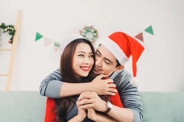 Feliz Hombre Santa Sombrero Rojo Abrazando Mujer Sentada Sofá —  Fotos de Stock