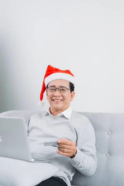 Senior Férfi Viselt Santa Kalap Vásárlás Laptop Hitelkártya Használatával Karácsonyfa — Stock Fotó